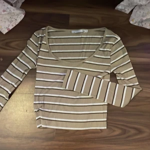 Randig tröja  - Säljer en randig långärmad tröja med urringning. Färgerna är brun/beige, vit och svart. 💕 den kommer från Lager 157 och är i dam storlek S 💕⭐️
