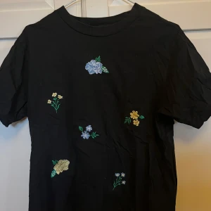 Svart t-shirt med broderie - Svart t-shirt från monki med broderade blommor. Passar som en strl S