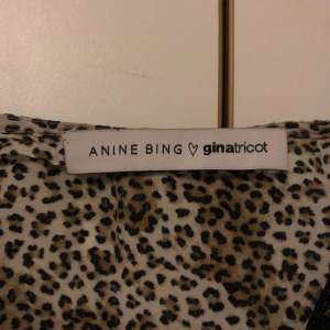 Snygg leopardmönstrad linnetopp med spetsdetaljer från Anine Bing x Gina Tricot. Toppen har tunna axelband och en avslappnad passform. Perfekt för att ge en trendig touch till din outfit.