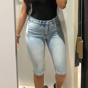 Ljusblå jeansshorts - Snygga ljusblå jeansshorts med hög midja och klassisk femficksdesign. Perfekta för varma sommardagar. De har en knapp och dragkedja framtill.