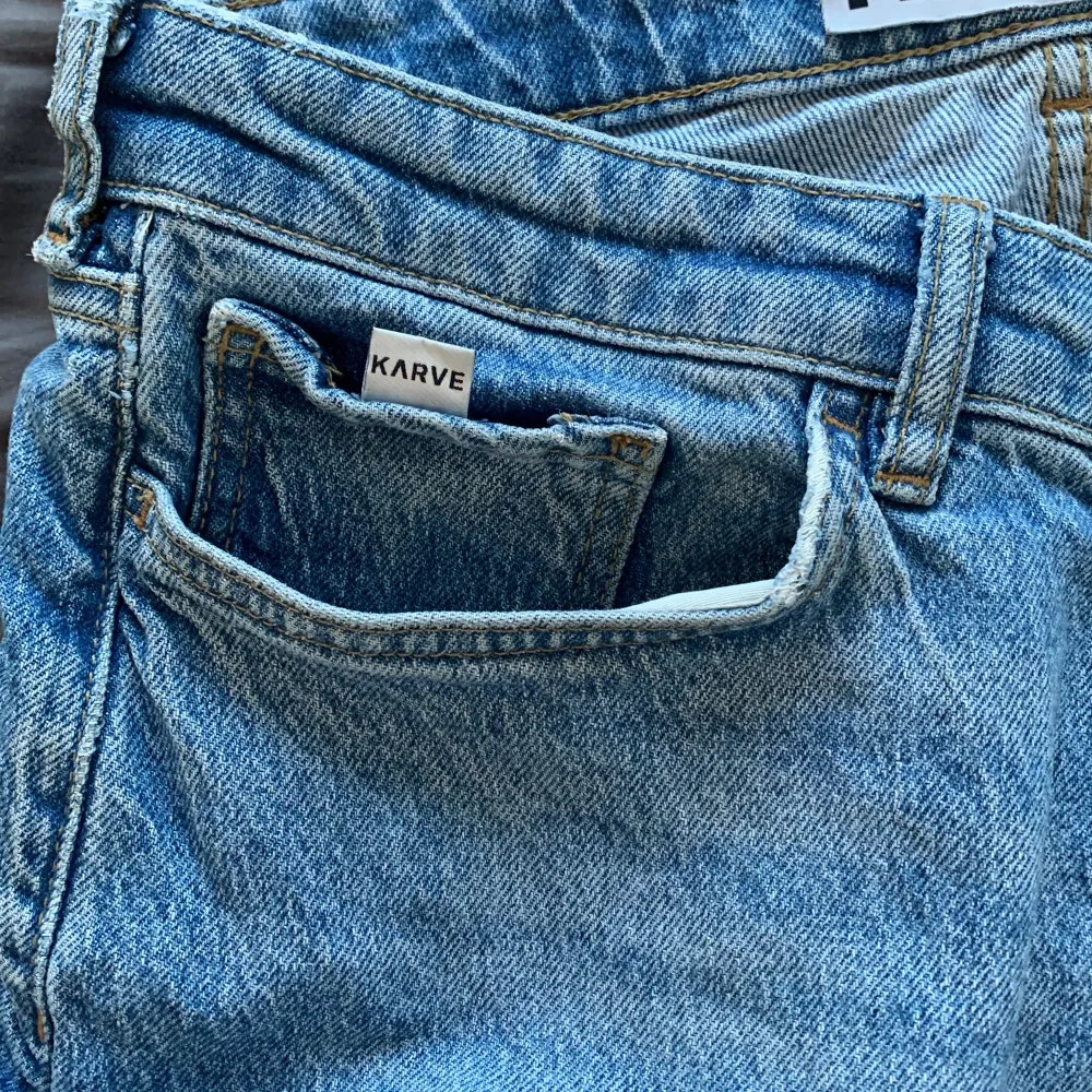 Säljer ett par klassiska blå jeans från Karve. De har en straight passform med normal midja och är tillverkade i denim. Perfekta för en avslappnad stil. Det är ett hål ned hela sidan på vänstra fickan men inget som syns utanpå.. Farkut & Housut.