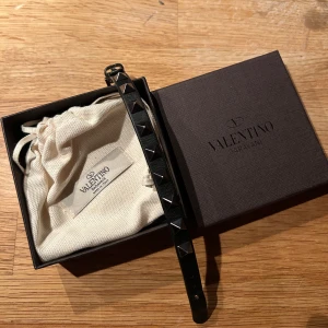 Svart Valentino armband med nitar  - Snyggt svart armband från Valentino. I grymt skick, knappt användt. Köpt i valentinos butik i rom, kvitto finns. Skriv om du har några frågor elle vill diskutera priset🤝
