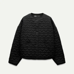 Svart quiltad jacka från Zara - Snygg svart quiltad jacka från Zara med hjärtmönster. Jackan har en rund halsringning och knäppning framtill. Perfekt för en stilren look.