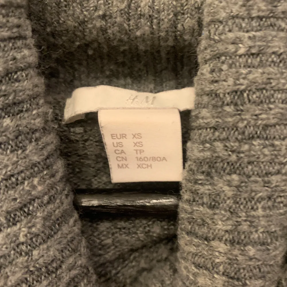 Mysig grå stickad polotröja från H&M. Perfekt för kyliga dagar med sin höga krage och långa ärmar. Enkel och stilren design som passar till det mesta.. Neuletakit & Villapaidat.
