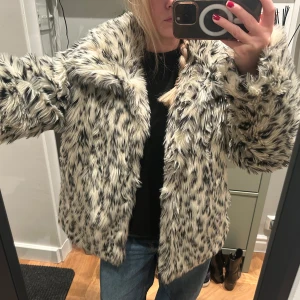 Fluffig pälsjacka från Monki - Säljer en supermjuk och fluffig pälsjacka från Monki i svart och krämvit. Jackan har en oversized passform och långa ärmar. Den här ett mindre hål i kragen som behöver sys ihop (bild5) men annars super bra skick!❤️ Storlek S