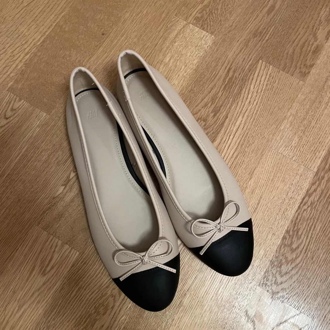 Beige och svarta ballerinaskor med rosett - 90