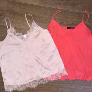 Två linne toppar med spetsdetaljer - Säljer två linne toppar, en i ljusrosa och en i korall. Båda har smala axelband och v-ringning. 