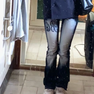 Mörkblåa jeans med broderi - Snygga mörkblåa jeans från Blue Queen med unikt broderi och stenar på fram- och baksida. Jeansen är bootcut! Midjemått 38cm rakt över och innerbenslångden är 80cm!