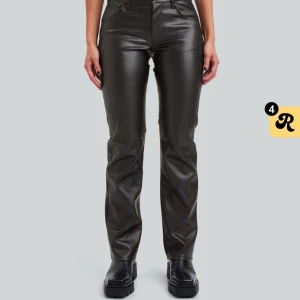 Svarta skinnbyxor från Bik Bok - Snygga svarta skinnbyxor från Bik Bok med låg midja och raka ben. Byxorna har en stilren design med knappar och dragkedja fram.