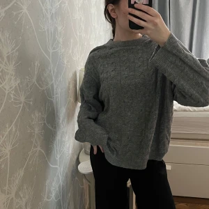 Grå stickad tröja - Mysig grå stickad tröja med kabelstickat mönster. Lite tunnare tröja med avslappnad passform och långa ärmar. Passar till det mesta😍