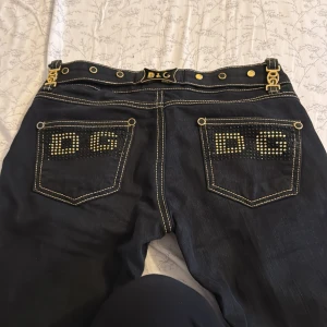 Svarta jeans från Dolce & Gabbana - Snygga svarta jeans från Dolce & Gabbana med gulddetaljer och logotyp på bakfickorna. Helt nya och vintage. Dom är lågmidjade.  PRIS KAN DISKUTERAS!! ❤️