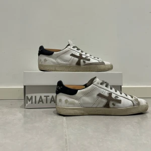 Premiata skor - Säljer dessa sjukt snygga och unika skor från premiata i färgen vit, med org slitningar. Skorna är använda men har tagits hand om otroligt väl. Extra snören och box medföljer. Og såklart. Dessa är väldigt eftertraktade och svåra att hitta. Nypriset låg på 3400 kr. Mitt pris är inte hugget i sten, så vid frågor, bud mm är det bara att kontakta mig🤝