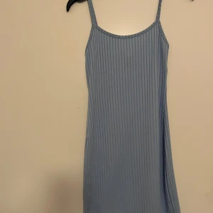 Ljusblå ribbad klänning - Snygg ljusblå klänning med smala axelband och ribbad design. Perfekt för varma dagar med sin enkla och stilrena look.