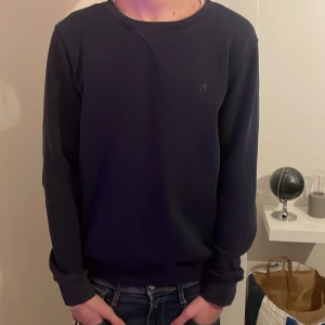 Mörkblå tröja från Replay - Säljer en stilren mörkblå tröja från Replay. Tröjan har långa ärmar och en diskret logga på bröstet. Perfekt för en avslappnad look. Skicket är bra men finns ett litet hål vid lappen bak. Tvätt lapparna är även borta