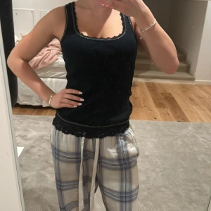 Svart linnetopp från EDC by Esprit - Snygg svart linnetopp från EDC by Esprit med spetsdetaljer vid halsringning och nederkant. Perfekt för en stilren look. Tillverkad i ett mjukt och bekvämt material.