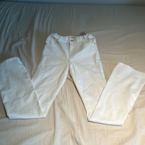 Vita jeansbyxor från ONLY - Snygga vita jeansbyxor från ONLY med dragkedja och knapp framtill. Byxorna har en klassisk design med fem fickor och är perfekta för en stilren look. Passar bra till både vardag och mer uppklädda tillfällen.