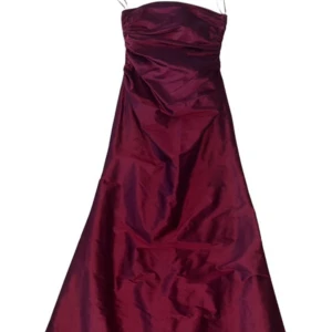 Vinröd axelbandslös balklänning - stiglund - Elegant vinröd axelbandslös klänning i glansigt material. Perfekt för festliga tillfällen med sin långa, svepande design.    Mått -   Midja 31  Byst 35  Stussvidd 48 Längd topp till tå: 131