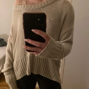 Beige stickad tröja - Mysig beige stickad tröja med en loose passform och offshoulder-design. Perfekt för kyliga dagar med långa ärmar och ribbade detaljer vid ärmslut och nederkant.💞
