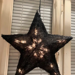 Svart stjärnformad lampa, kabellängd 3,5 m - Snygg svart stjärnformad lampa som ger ett mysigt sken. Perfekt för att skapa stämning i hemmet, särskilt under julen. Lampan är tillverkad av ett nätliknande material och hängs enkelt upp i fönstret.