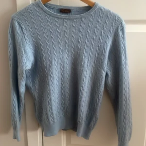 Stenström kabelstickad tröja - En kabelstickad tröja i merinoull från stenström. Jag säljer nu denna tröja eftersom den har växt ur mig. Skick 9/10 inga defekter. Storlek XS. Färg: ljusblå. Dm för frågor eller funderingar 😃