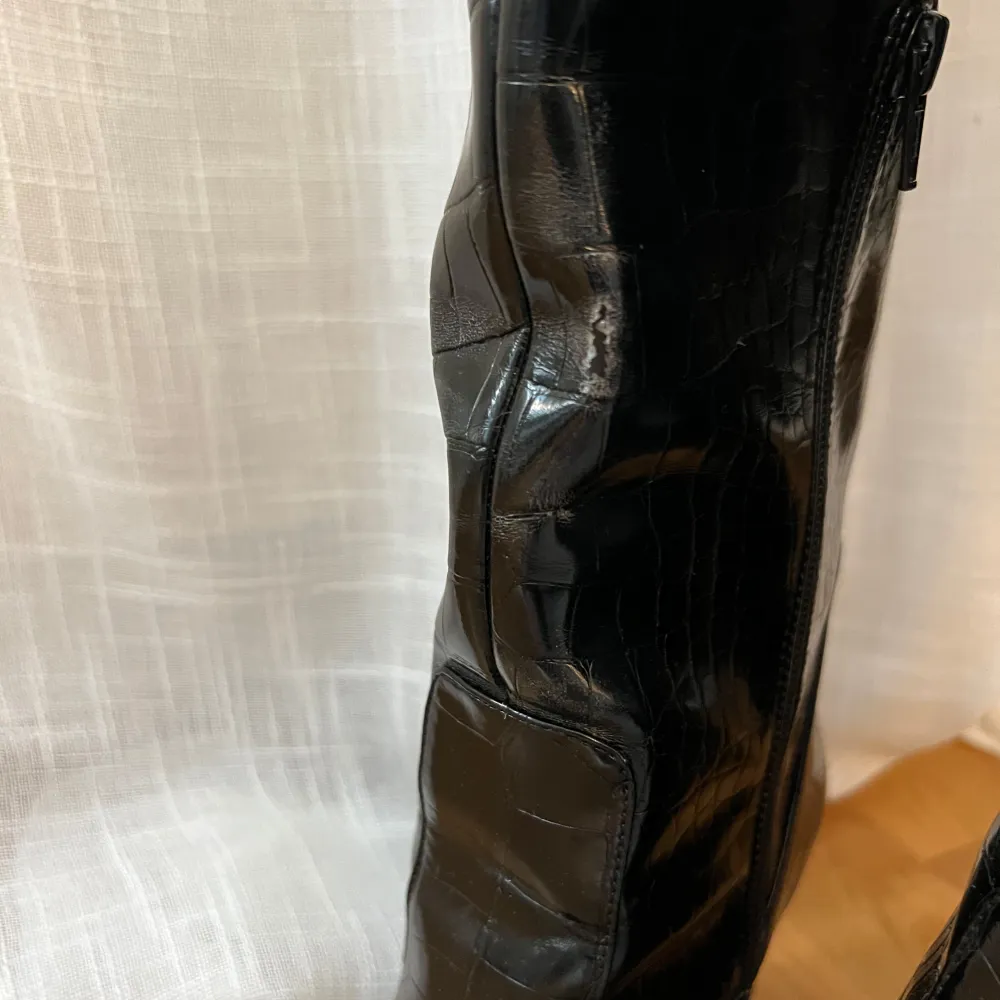 Snygga svarta stövlar i krokodil imitation med spetsig tå och klack. Säljer för det kommer inte till användning. Några defekter ( se bilder )💖nypris 899kr. Kengät.