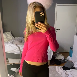 Rosa ribbad topp - Säljer en snygg rosa ribbad topp med långa ärmar. Toppen har en rund halsringning och är perfekt för en trendig look. Passar bra till både jeans och kjol.