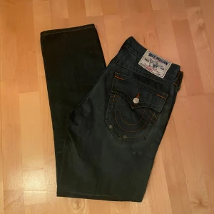 Mörkblå jeans från True Religion - Säljer nu sjukt feta jeans från true religon! Nästan helt nya med skit snygga slitningar på framsidan. Sitter straight fast med lite flaird. Pris kan diskuteras👍