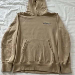 Beige hoodie från Champion - Säljer en snygg beige hoodie från Champion med klassisk logga på bröstet. Tröjan är i mycket bra skick helt utan skador och defekter. Den är i storlek L men passar även M. Hör gärna av er vid frågor. Mvh Eric