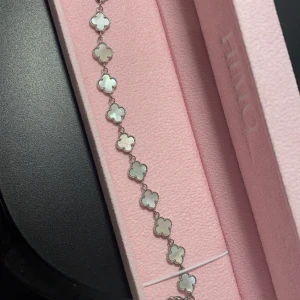 Silverfärgat armband med fyrklöverdesign - Elegant armband från Himo med silverfärgade fyrklöverformade länkar. Perfekt för att ge en stilren touch till din outfit. Kommer i en rosa presentask. Samt vattentåligt 