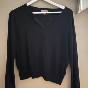 Svart kofta från H&M - Säljer en klassisk svart kofta från H&M. Den har långa ärmar och knappar framtill. 🖤Den är i bra skick! Storlek M men passar S. Köptes för 199 kr💞