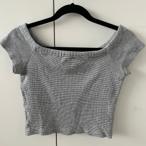 Grå topp - Snygg grå topp med en fin, mjuk urringning. Toppen är kortärmad och har en tight passform som framhäver figuren snyggt! 💘💘