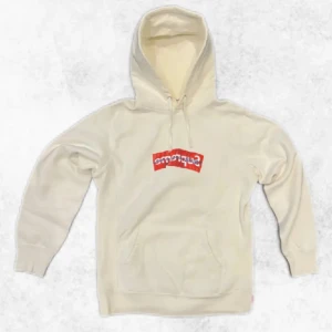 Vit hoodie från Supreme x Comme des Garçons - Säljer en vit hoodie från Supreme i samarbete med Comme des Garçons. Hoodien har en unik röd och vit logga på bröstet och är i riktigt fint skick. Den är liten i storleken, det står L men passar mer som M