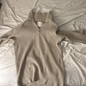 Beige ribbad tröja från Jack & Jones - Säljer en stilren beige ribbad tröja från Jack & Jones. Tröjan har en dragkedja framtill och en hög krage som ger en snygg look. Perfekt för kyligare dagar. Passar bra till både jeans och chinos. Storlek XS men passar även S