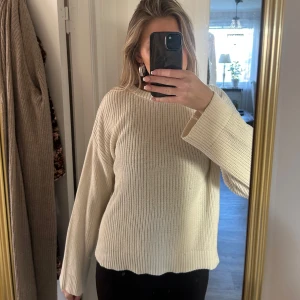Beige stickad tröja från NA-KD - Beige stickad tröja från NA-KD. Passar till det mesta!! Använd fåtal gånger🩷Färgen är lite gräddvit!