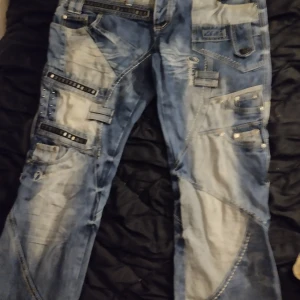 Blå jeans med nitar och detaljer - Snygga blå jeans med unika detaljer och nitar. De har flera fickor och en cool tvättad look. Perfekta för dig som vill sticka ut med din stil.