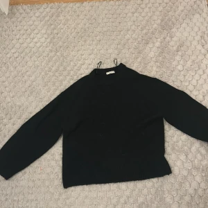 Svart tröja från Gina Tricot - Säljer en stilren svart tröja från Gina Tricot i storlek M. Tröjan har långa ärmar och är tillverkad i ett mjukt material som ger en bekväm passform. Perfekt för kyligare dagar.