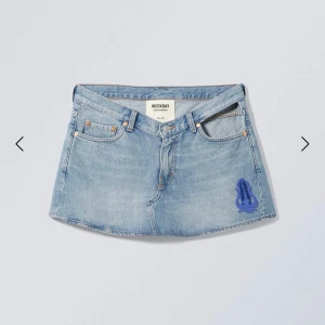 Jeanskjol från Weekday - Snygg jeanskjol från Weekday i en klassisk blå denim. Kjolen har en unik blå broderad detalj på framsidan och är en del av en limited edition-kollektion. Perfekt för en trendig look! Original pris 550. 