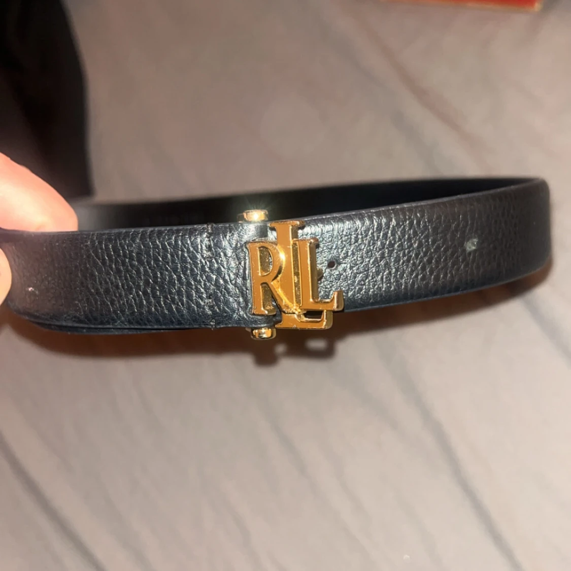 Svart bälte med gulddetaljer