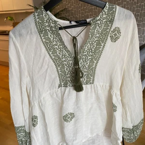 Blus från zara - Fin blus i créme färg med gröna detaljer från zara. Helt ny med prislapp kvar!