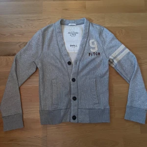 Cardigan från Abercrombie & Fitch - Säljer denna gråa cardigan från Abercrombie & Fitch i storlek S. Skriv gärna vid frågor!