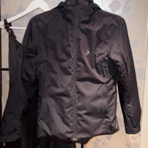 Svart jacka från Peak Performance - Säljer en svart skidjacka från Peak Performance med dragkedja och huva. 