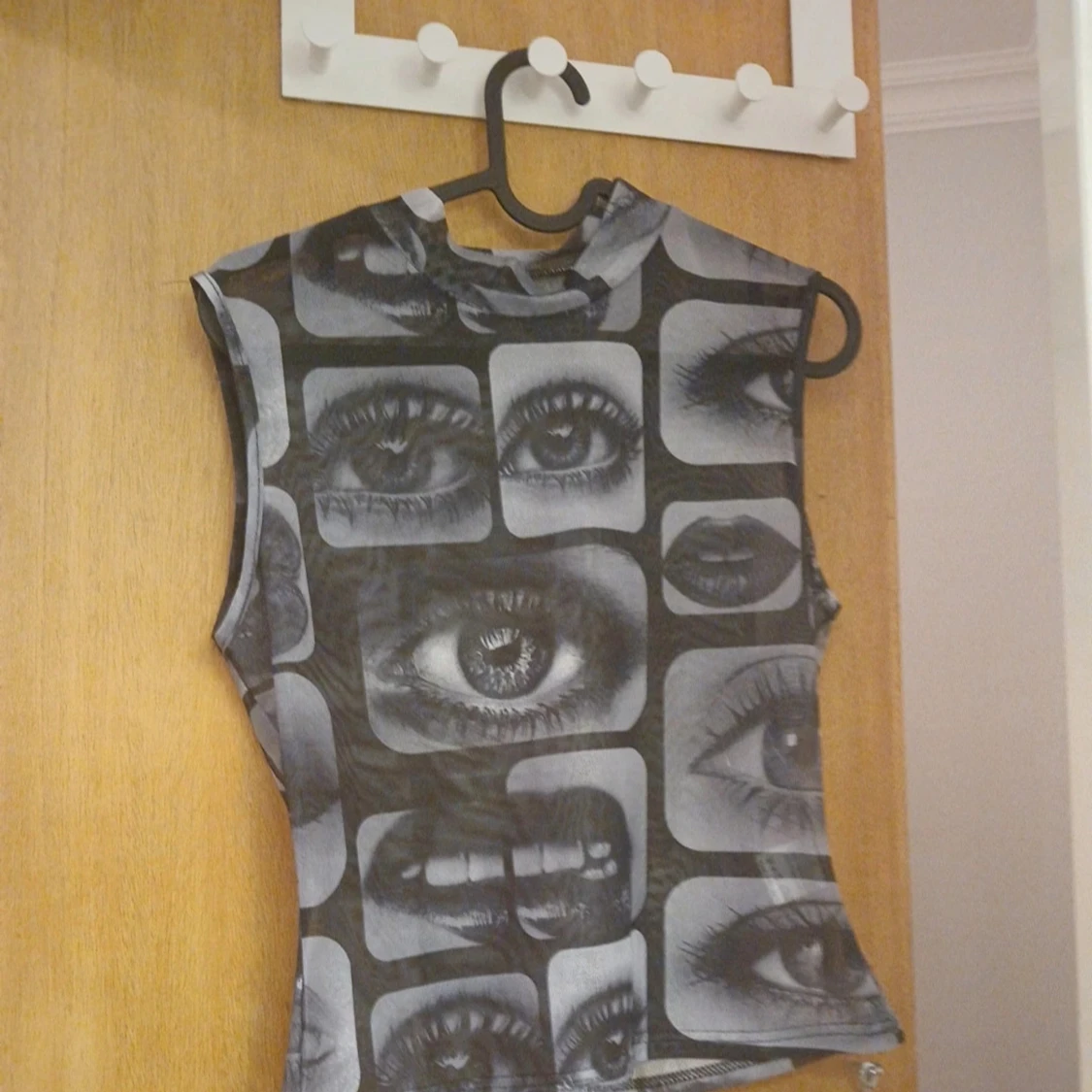 Svart och grå ärmlös topp med ögon- och munmönster