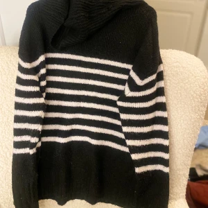 Svart och vit randig hoodie - Säljer en svart och vit randig hoodie med långa ärmar. Perfekt för en avslappnad stil. Den har en bekväm passform och är gjord i ett mjukt material.