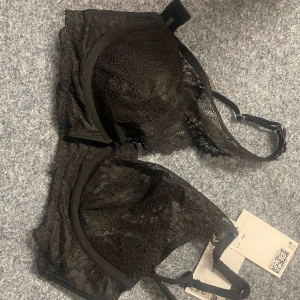 Svart spets-bh från H&M - Säljer en elegant svart spets-bh från H&M. Den har justerbara axelband och en vacker spetsdesign som ger en lyxig känsla. Perfekt för att känna sig extra fin under kläderna. Ny med tag kvar.