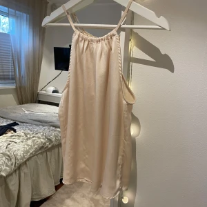 Beige topp/linne - Säljer en stilren beige ärmlös topp med smala axelband och knytband i ryggen storleken står inte men passar som s. 💖