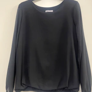 Svart blus från Hailys - Elegant svart blus från Hailys med långa ärmar och rund halsringning. Perfekt för en stilren look. Tillverkad i ett lätt och luftigt material som ger en bekväm passform. Skriv för fler bilder eller om ni har fler frågor 💓