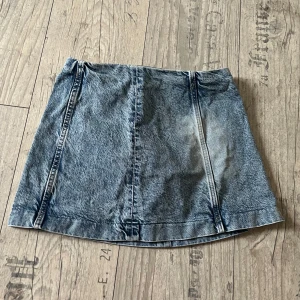 Jeanskjol från H&M - Säljer en snygg jeanskjol från Divided i storlek 32. Kjolen är i klassisk blå denim och har en kort modell som passar perfekt till både vardag och fest. Som sagt, är den lågmidjad och sitter vid höften😊Den är 30,5 cm lång och 33,5 cm (mätt rakt över) vid midjan. Den är oanvänd, då den är förkort för mig.