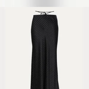 Svart prickig långkjol - Snygg svart långkjol med små vita prickar. Kjolen har en elegant och tidlös design som passar perfekt för både vardag och fest. Från Realisationspar! 