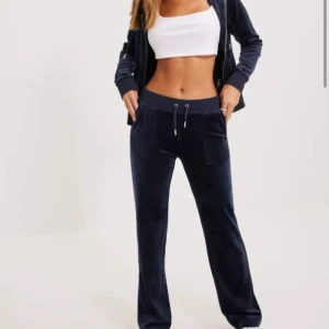 Marinblå juicy byxor - Säljer mina mörk blå juciy byxor, dom är använda men kommer inte till användning längre. Super bekväma! en av metallen på snöret är borta, men funkar lika bra ändå❣️ köpte för 1200