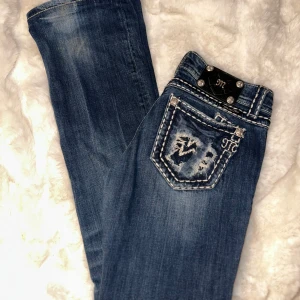 Blå jeans med slitna detaljer - Säljer ett par snygga blå jeans från Miss Me i storlek 28. Bootcut modell💞